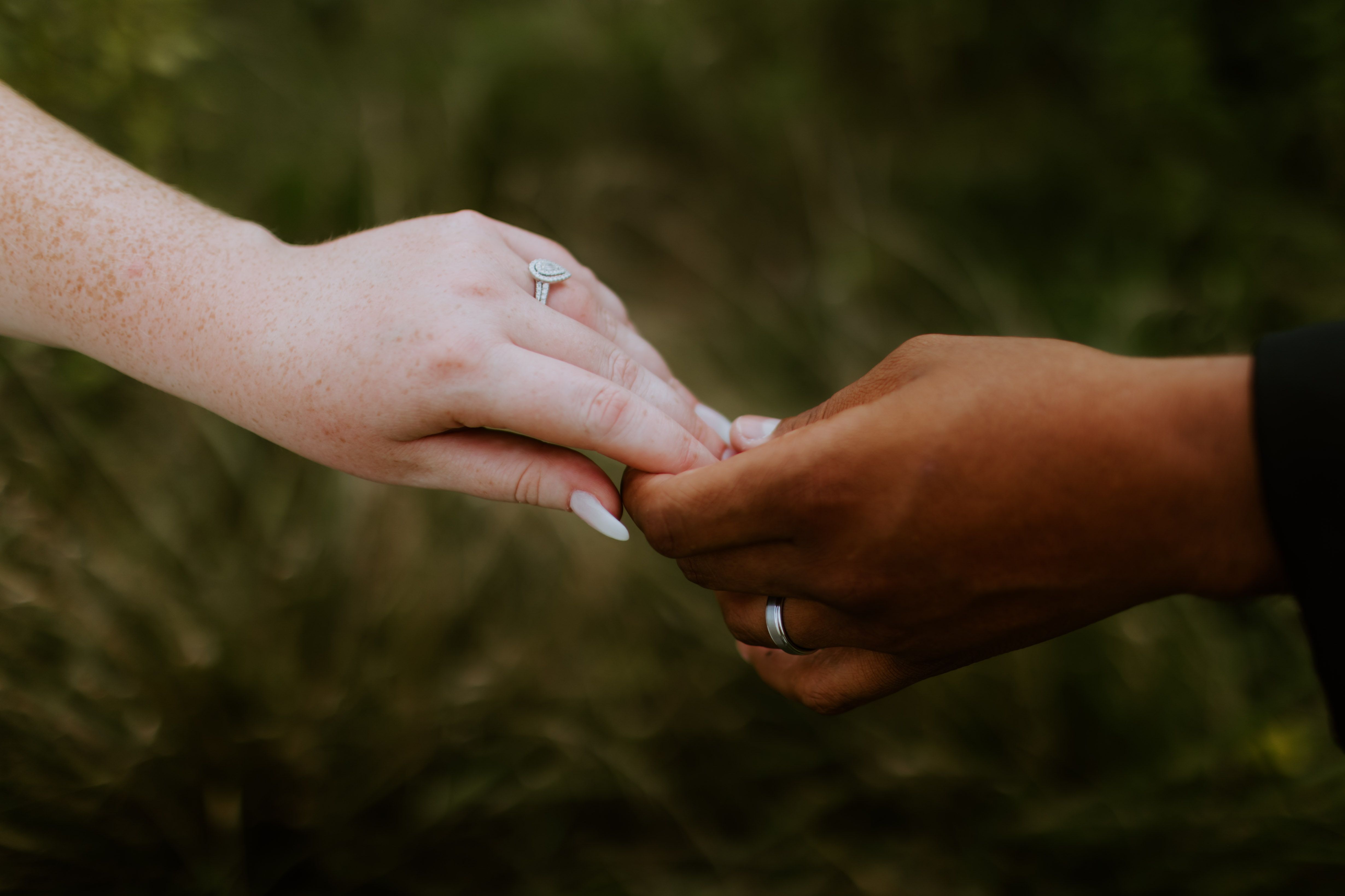 Close-up of an interracial couple holding hands, symbolizing love and unity.