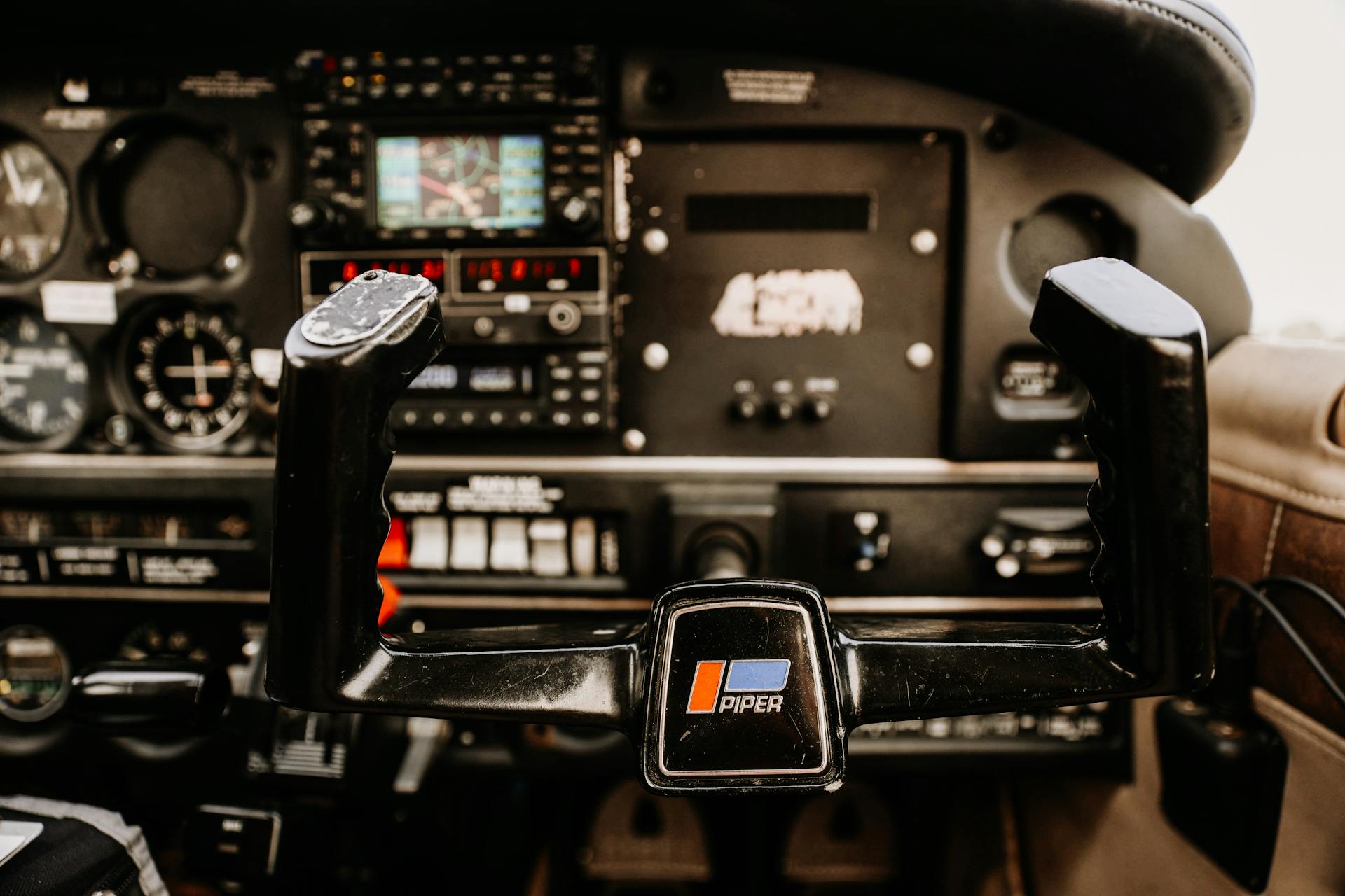 Detailed image of an aircraft cockpit showing controls and instrumentation inside a Piper plane.