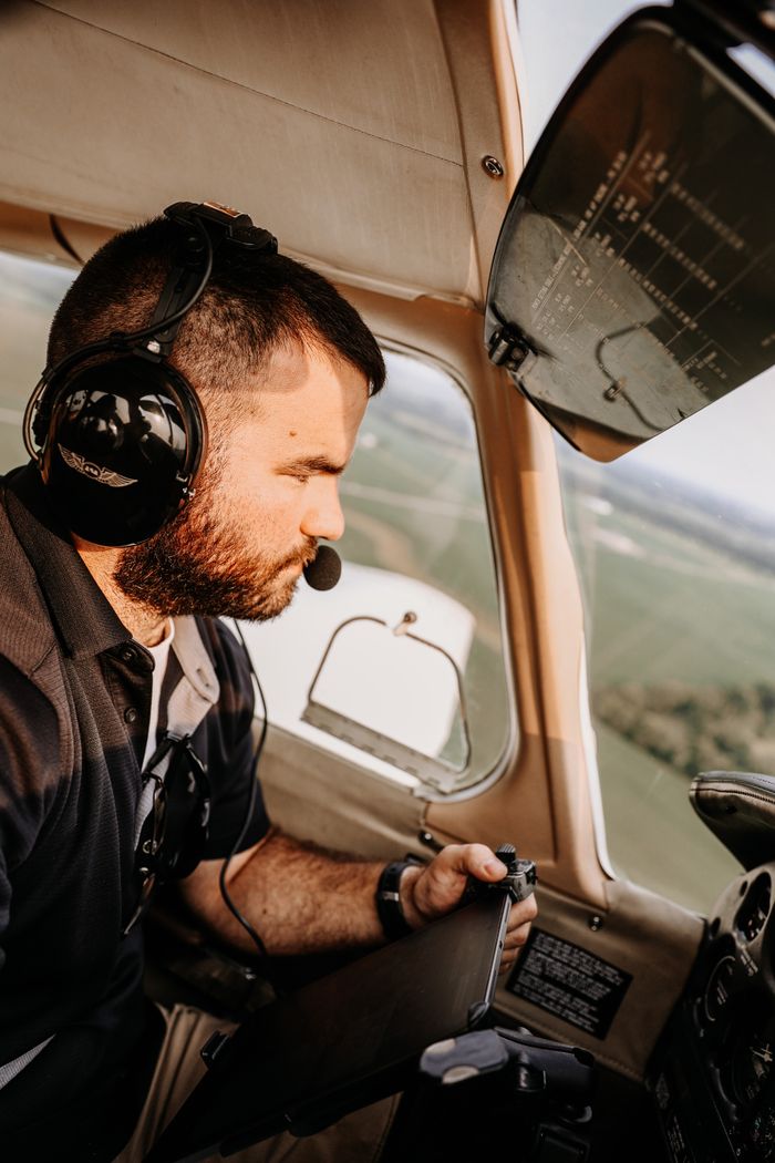 Focused pilot with headset navigating small aircraft in flight