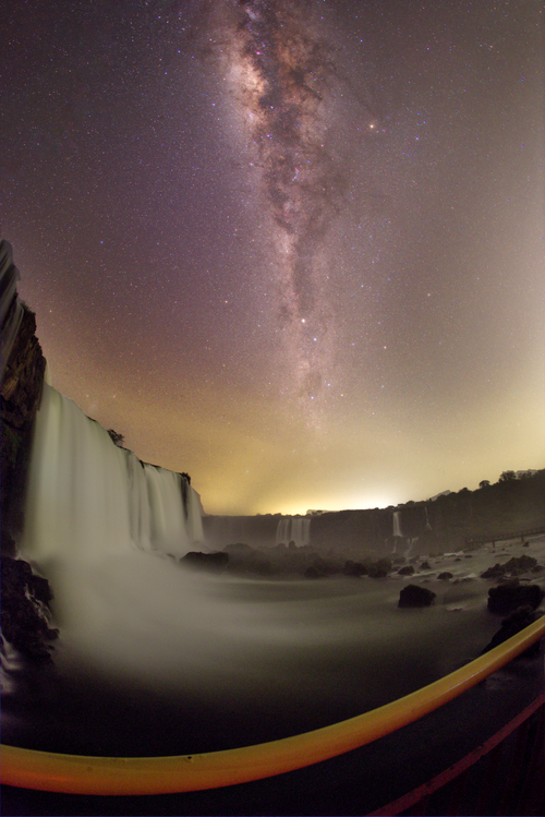 Free Breathtaking fisheye view of the Milky Way galaxy over a majestic waterfall at night, creating a mesmerizing landscape. Stock Photo