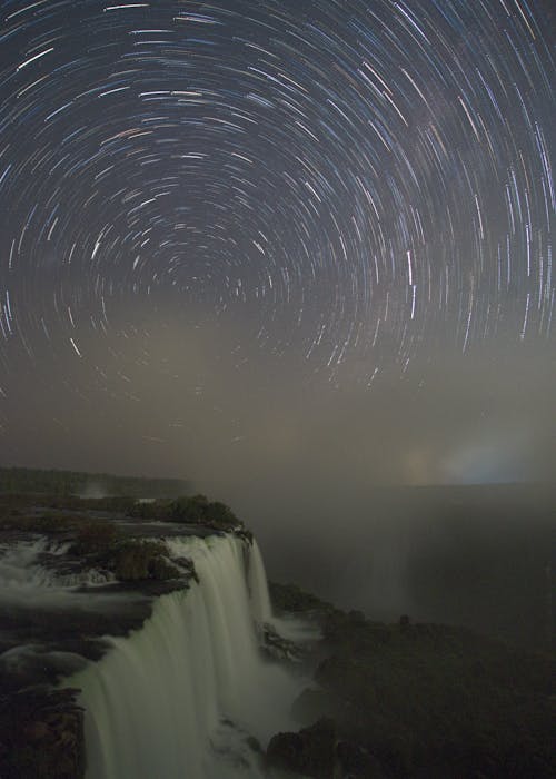 Lights on Sky over Waterfalls at Night