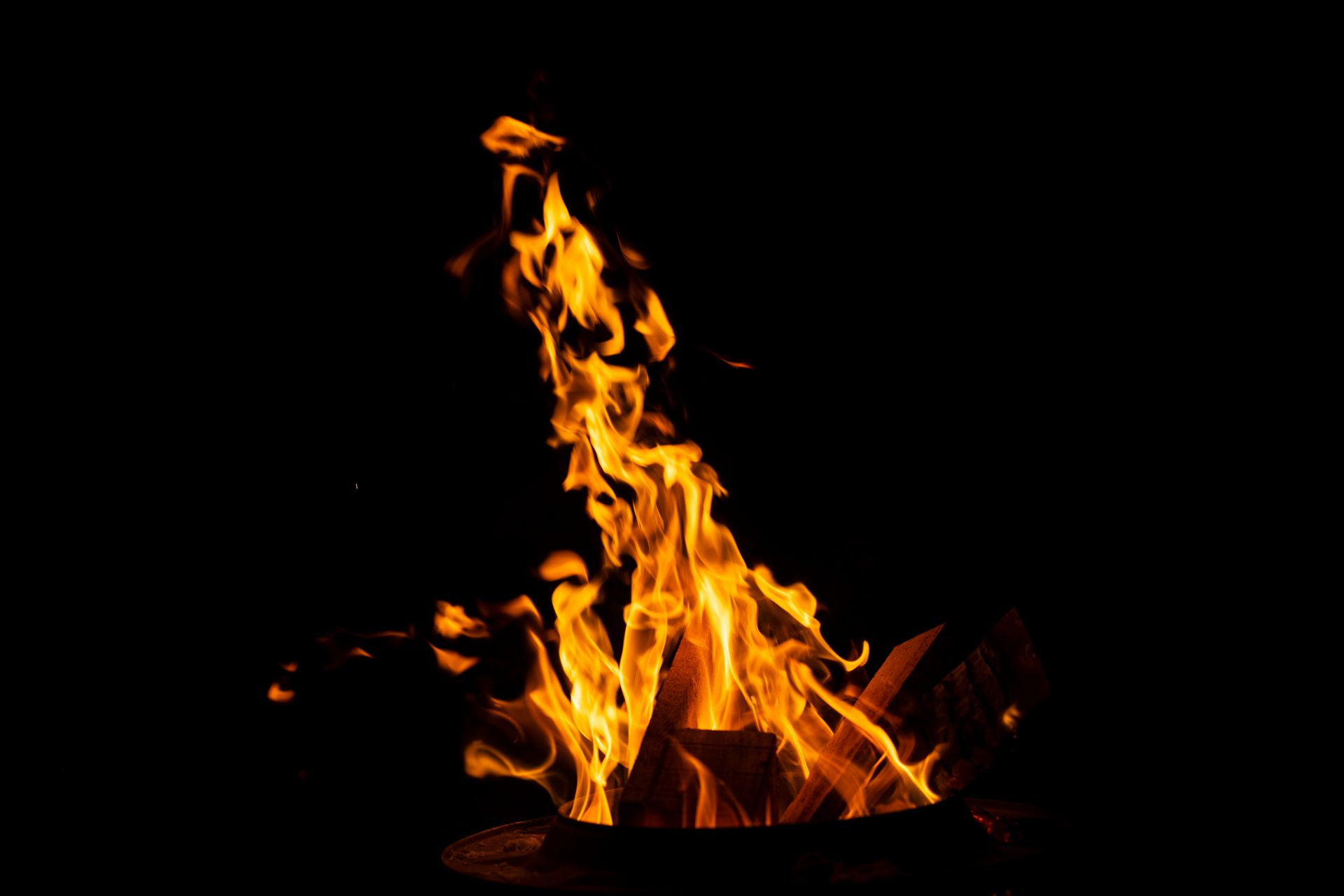 Dynamic flames from a campfire creating warmth and light against the night sky.