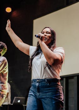 A woman passionately sings into a microphone on stage. Ideal for music and entertainment events imagery.