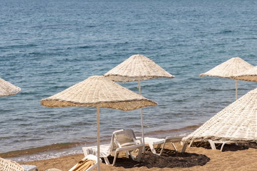 Relaxing beach scene with wicker umbrellas and lounges by the sea. Perfect summer getaway.