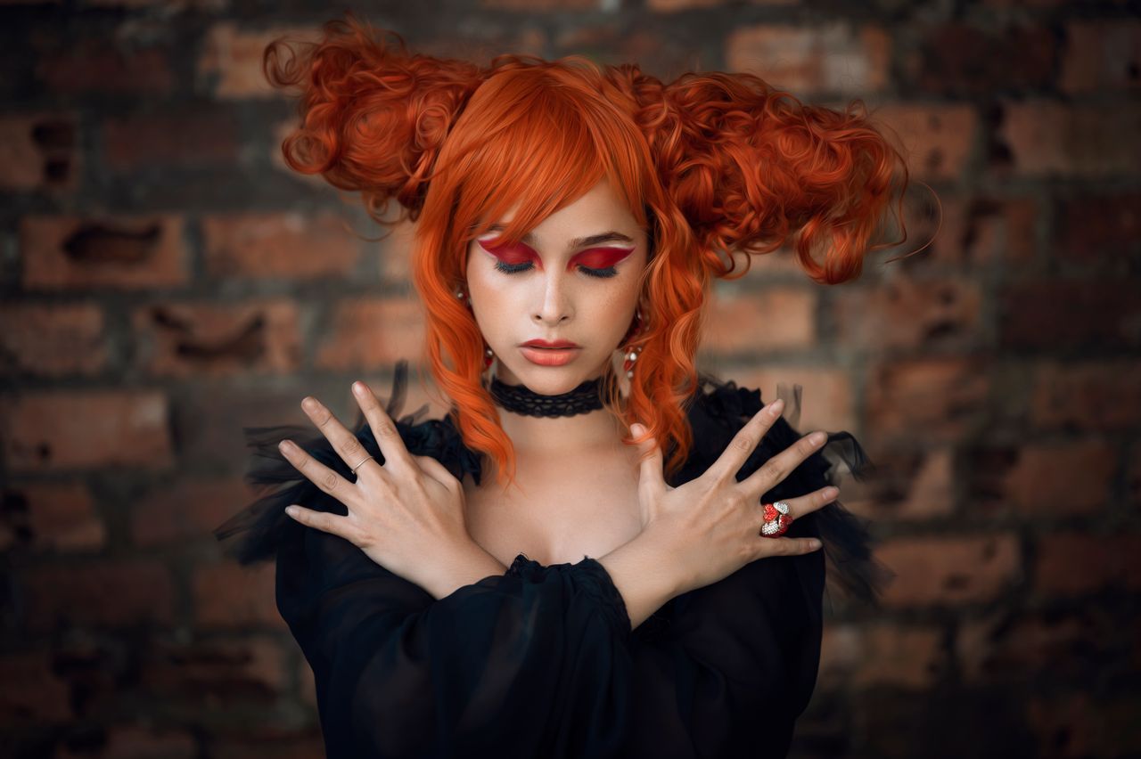 artistic portrait of a woman with vibrant red hair eyes closed posing