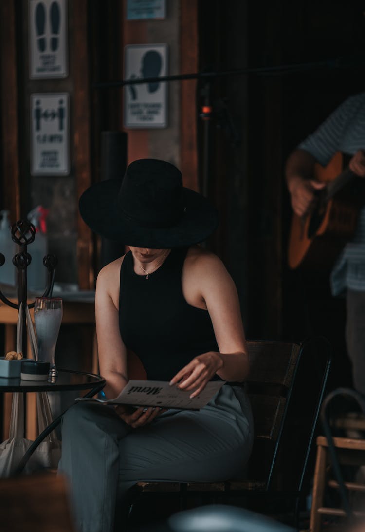 A Woman Reading A Menu In A Restaurant