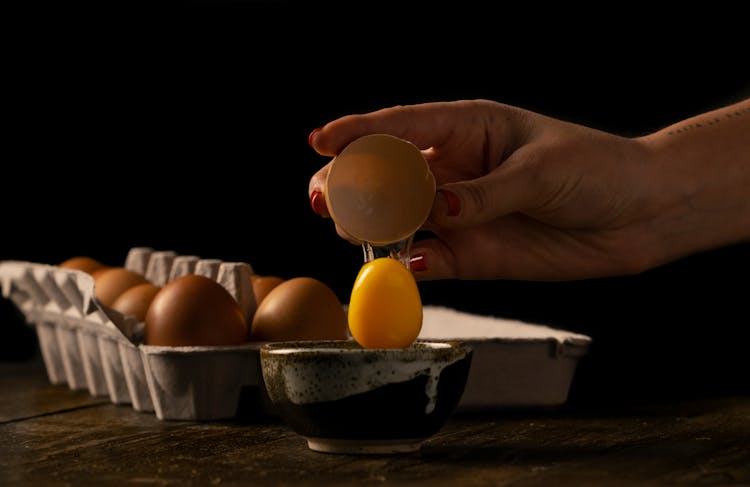 Person Cracking An Egg On A Bowl