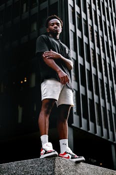 Confident young man posing in urban streetwear in downtown Toronto, showcasing modern fashion in an urban setting.