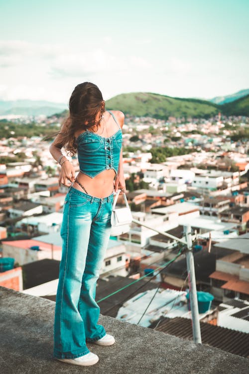 Free Woman in Denim Jeans and Top Standing on Top of the Building  Stock Photo