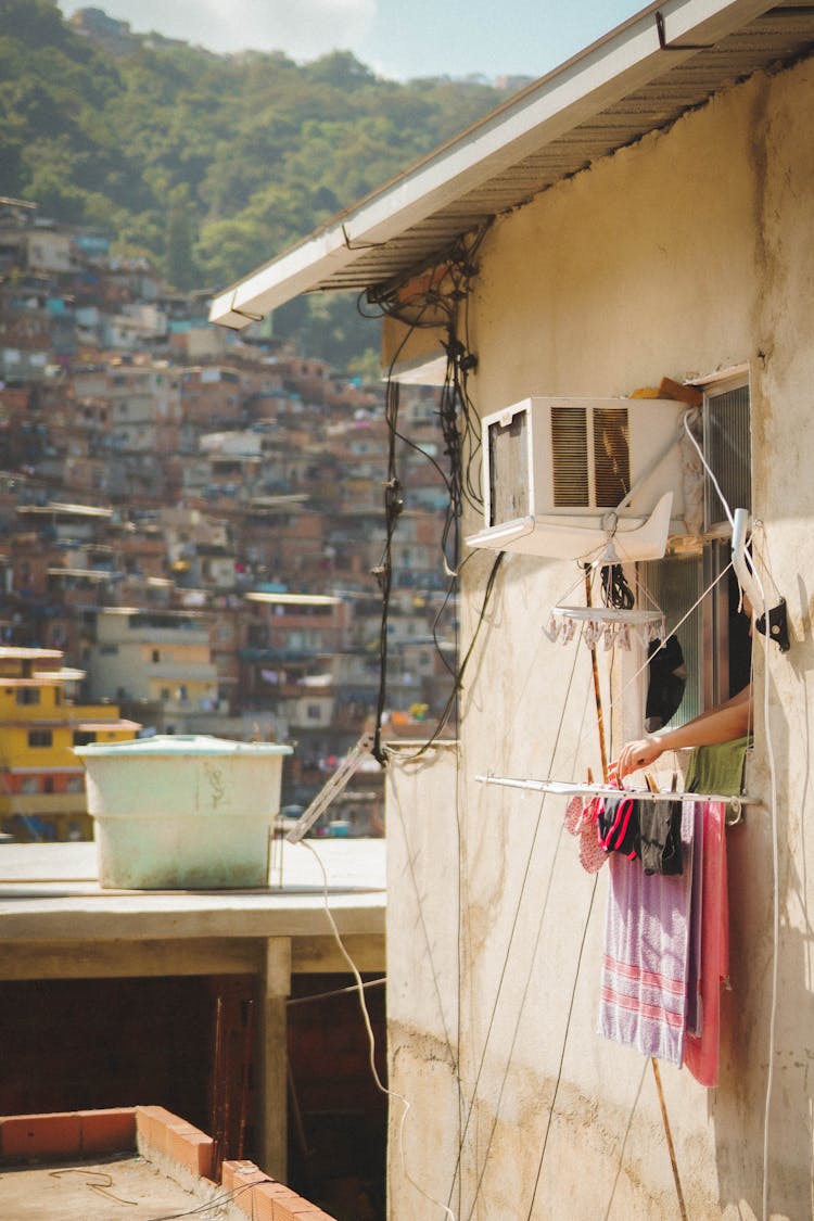 Person Hanging Clothes On Window