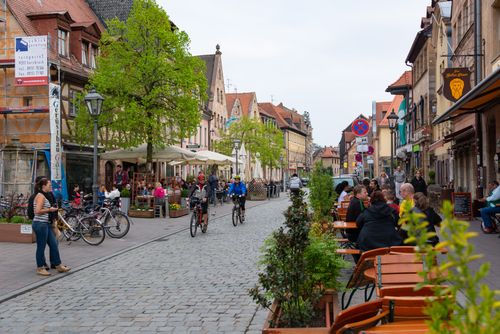 Free Bicyclists and people enjoying a quaint street café in historic Fürth, Germany. Stock Photo