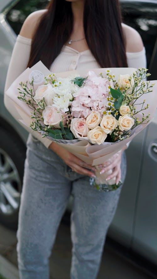 Free A Person Holding a Bouquet of Flowers Stock Photo