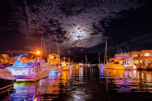 Boats on Body of Water Under Dark Sky