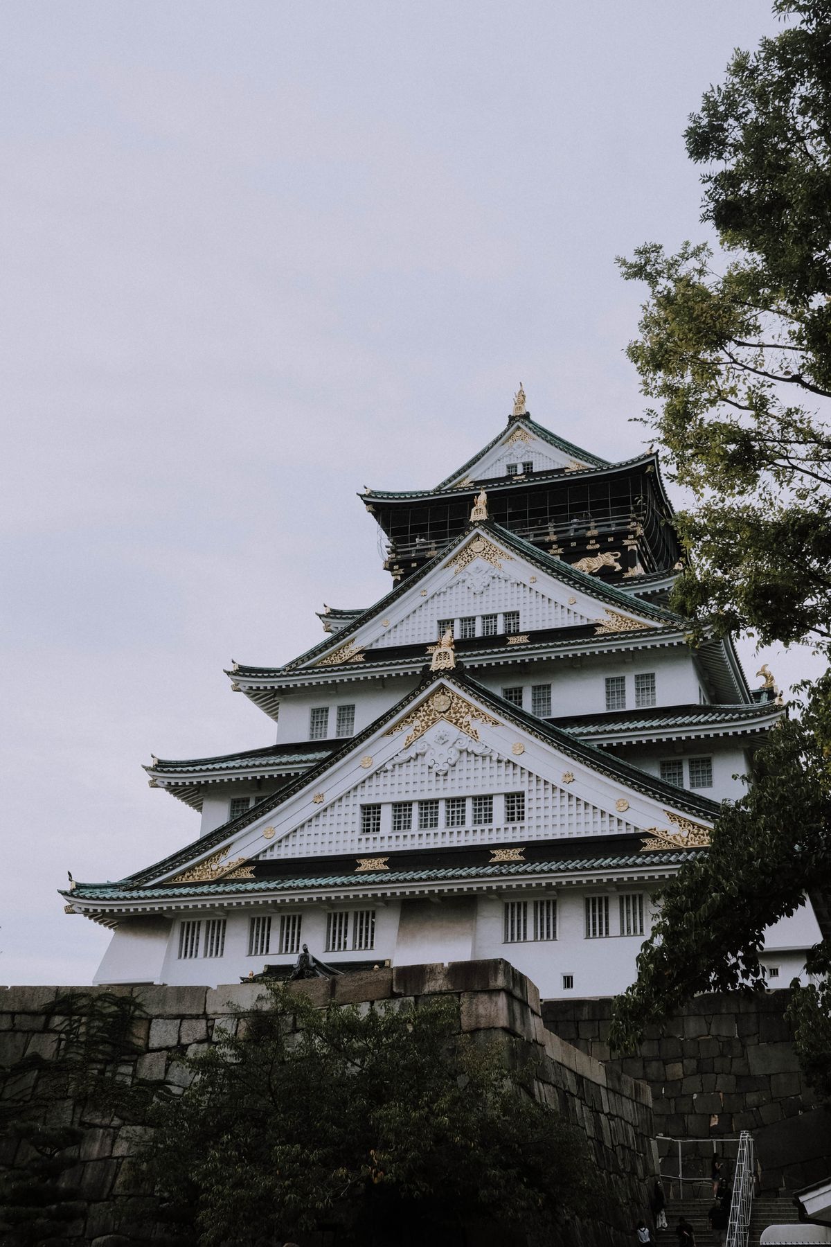 Osaka Castle surrounded by lush greenery on a serene day