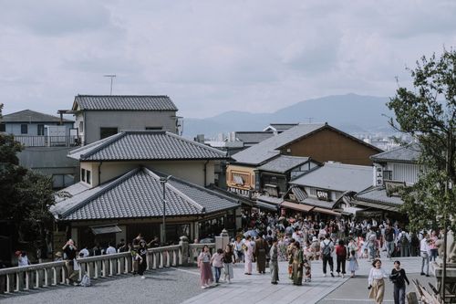 Free A bustling street in Kyoto with traditional buildings and people wearing kimonos. Stock Photo