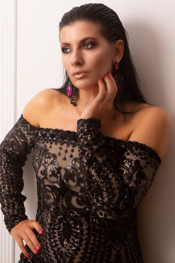 Woman posing elegantly in a sequined black dress