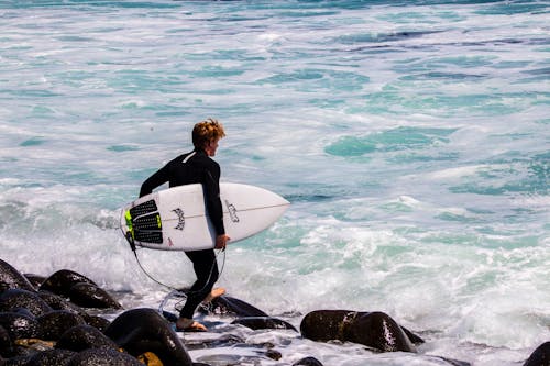 A Surfer Carrying a Surfboard