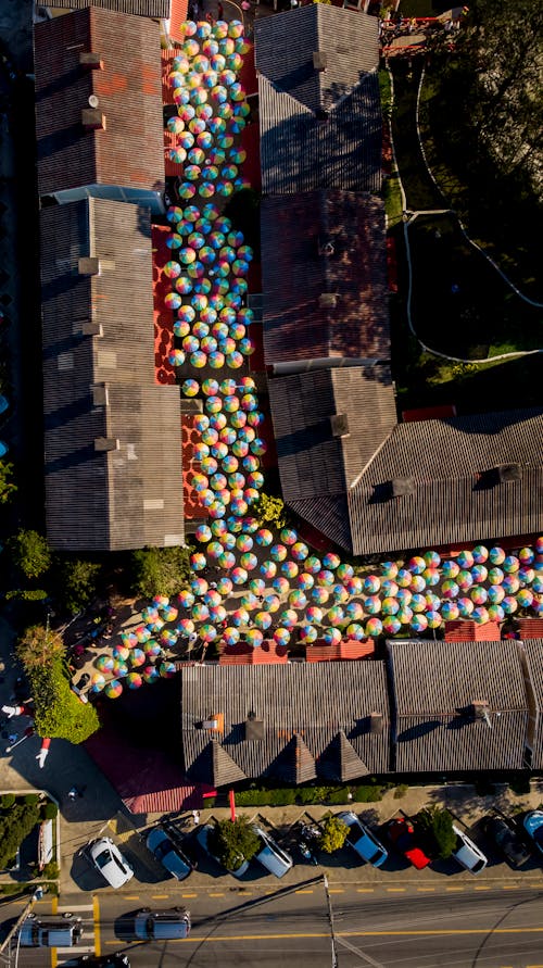 Aerial Photo of a Street Full of Multi Colored Umbrellas