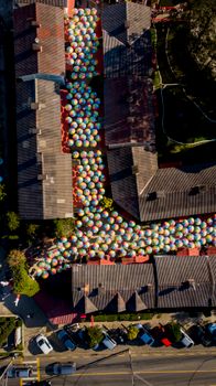 A vibrant aerial view of colorful umbrellas between terraced houses in Penedo, Brazil. Perfect urban art piece.