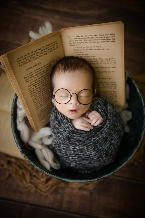 A Baby Wearing Eyeglasses While Sleeping 