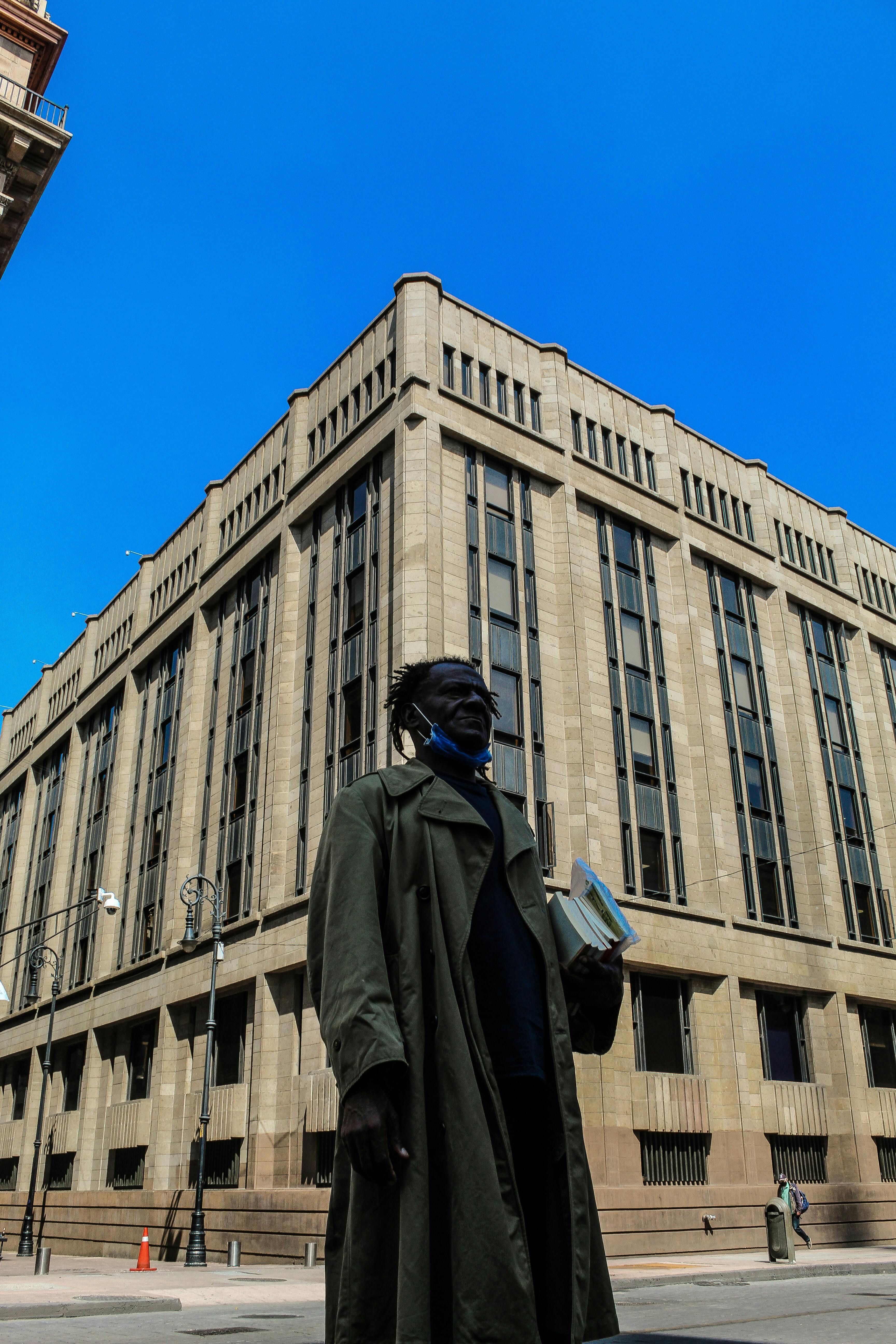 Free Art Deco building on a street corner in Ciudad de México with a passerby in the foreground. Stock Photo