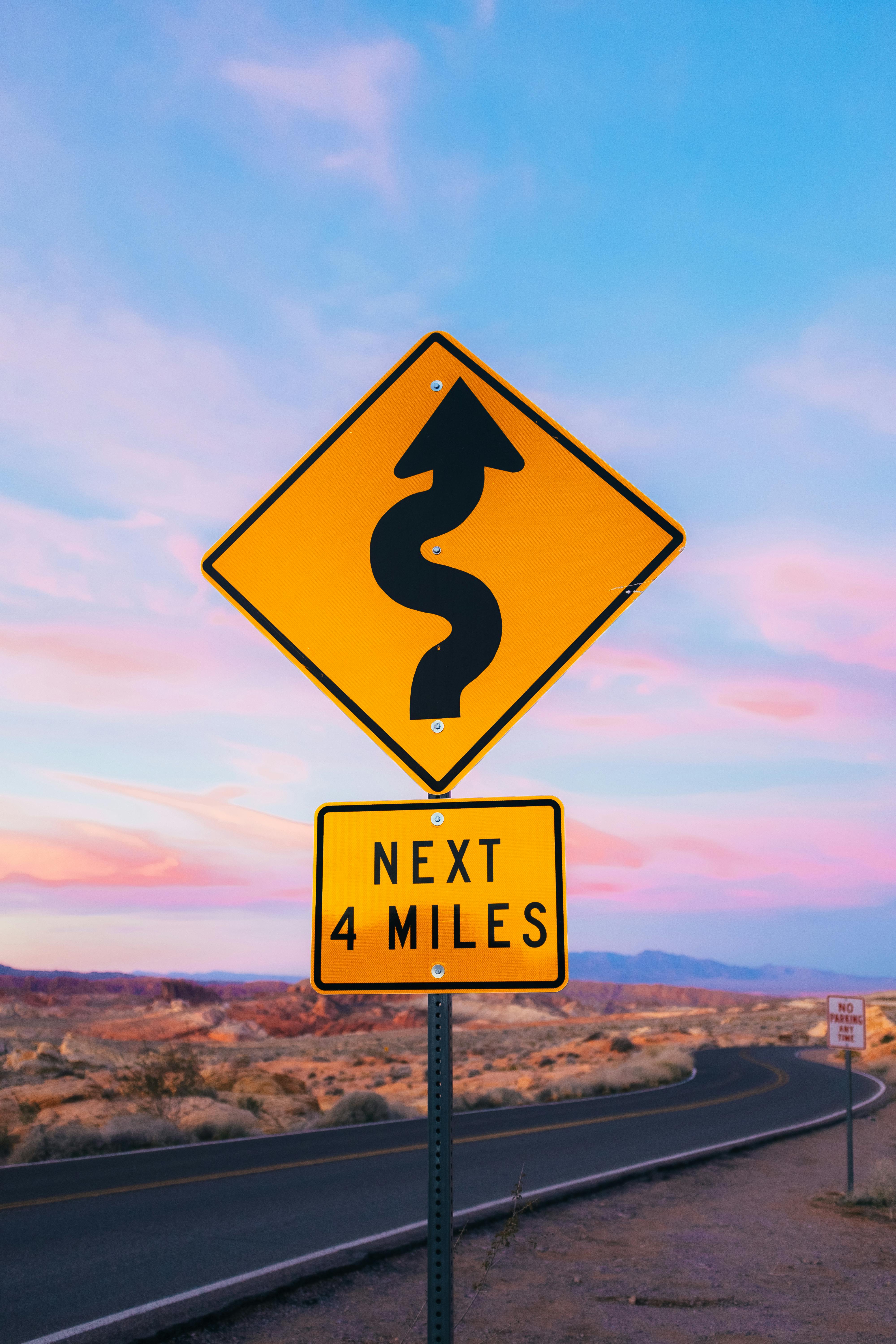 a winding road sign in the desert