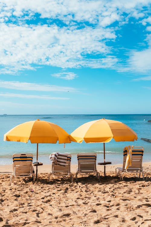 Brown Wooden Chairs and Table Near Sea Under Blue Sky