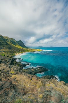 Breathtaking coastal landscape of Honolulu's vibrant blue sea and lush green hills.