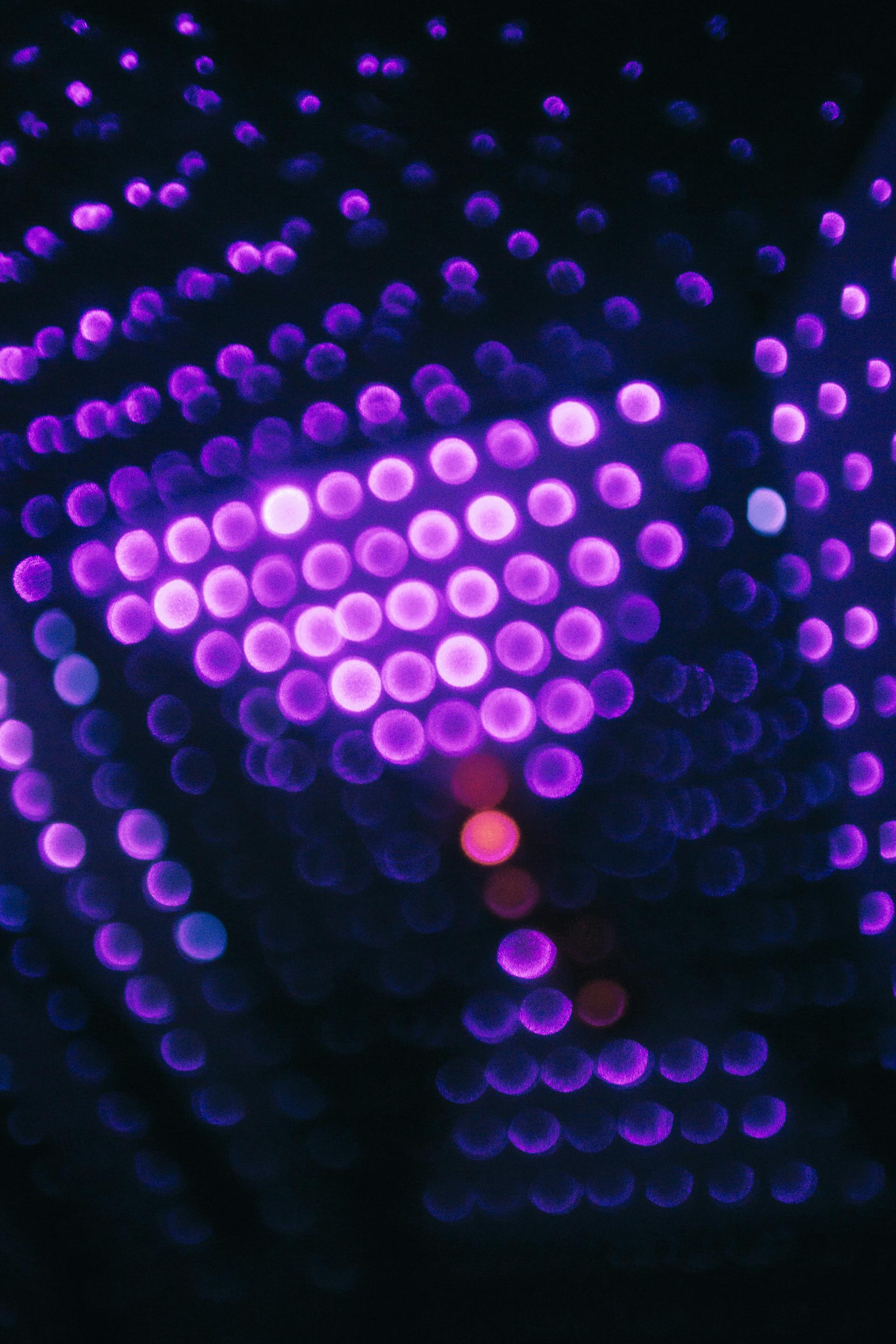Purple and pink bokeh lights creating an abstract defocused background.