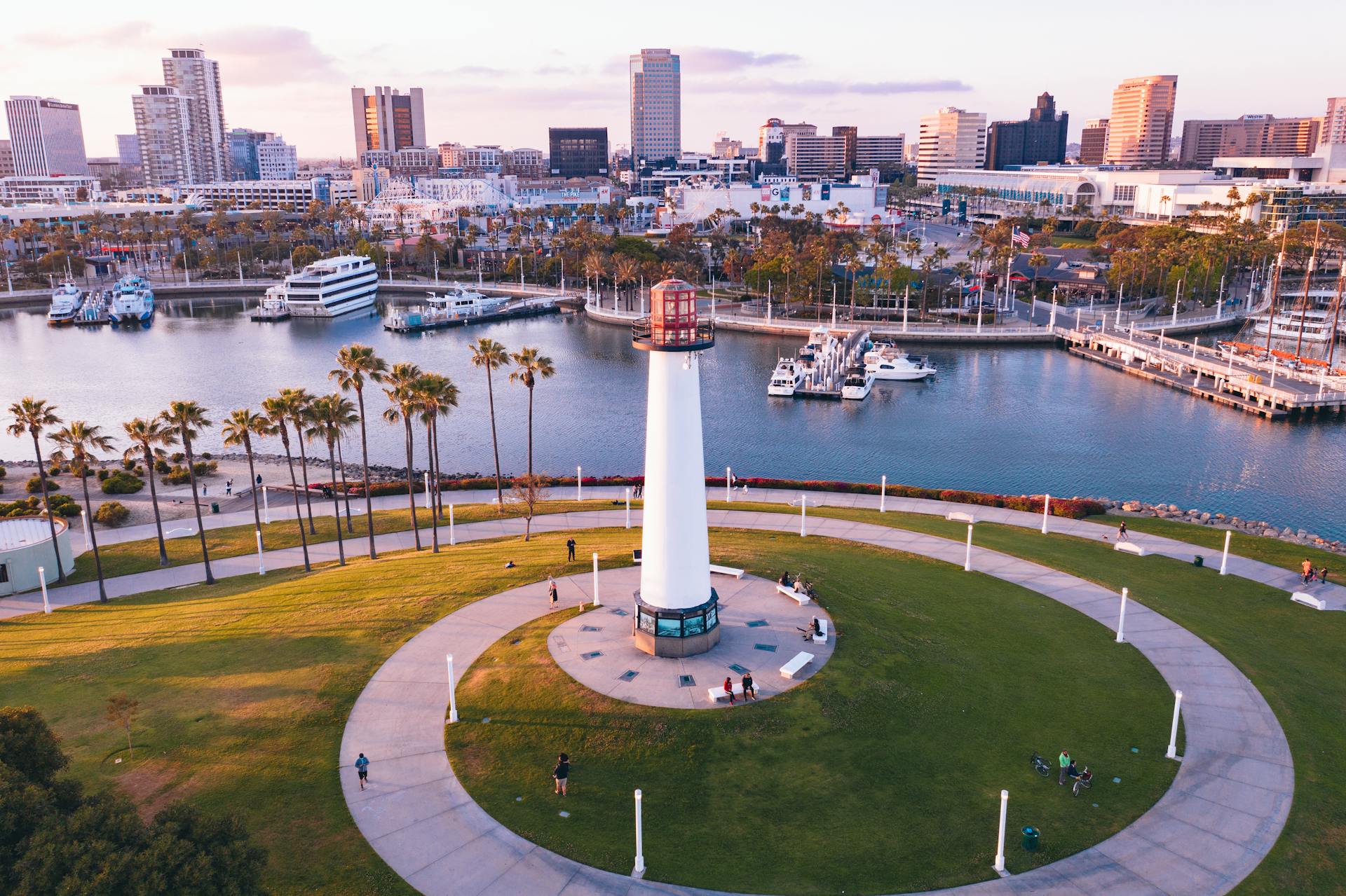 A stunning aerial shot of Long Beach Lighthouse and marina with city skyline at sunset.