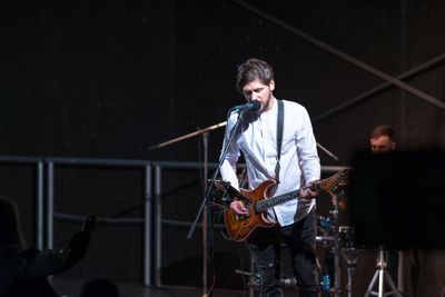 Musician performing on a lit stage — photo by Justinas Stanislovaitis on Pexels