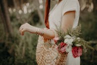A Person Carrying a Woven Handbag with Flowers