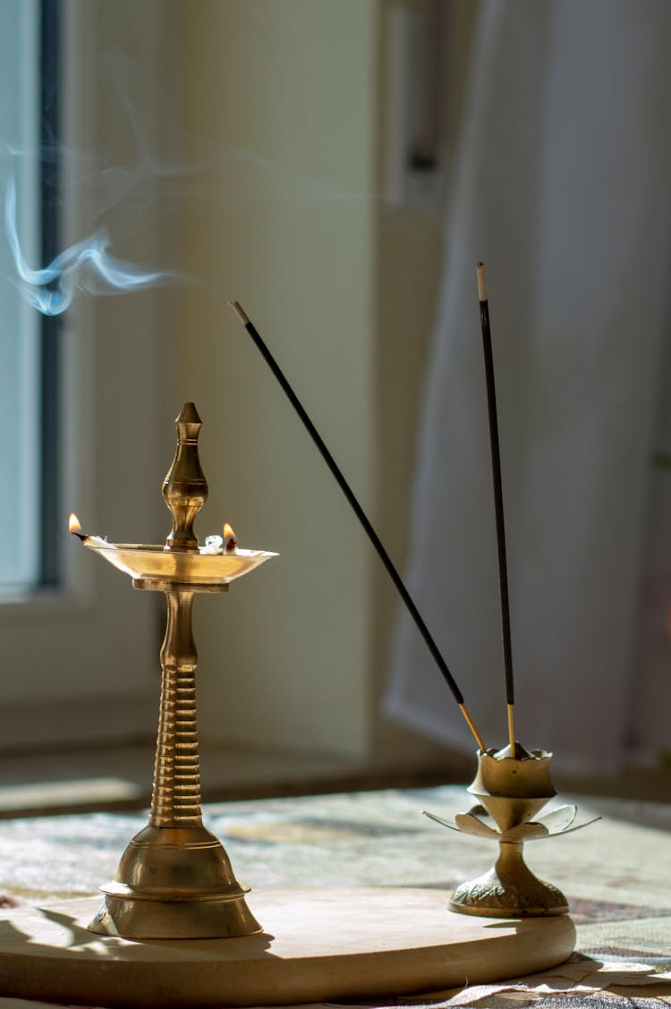 Burning Incense Sticks And An Oil Lamp 