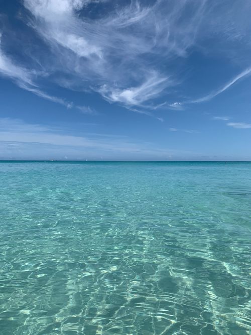 Free A tranquil seascape with clear turquoise waters and a blue sky, perfect for relaxation. Stock Photo