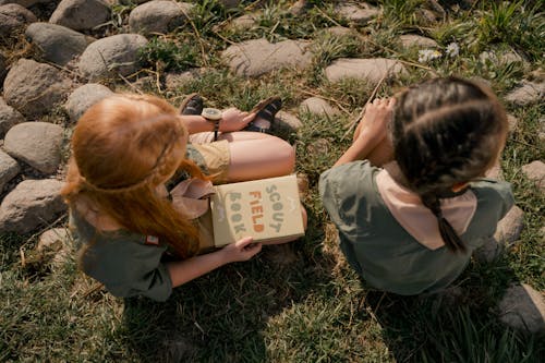 High-Angle Shot of Two Girls Sitting on the Ground