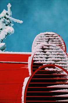 白雪覆盖的红色建筑在清爽蓝天的映衬下显得格外迷人，构成一幅冬日美景