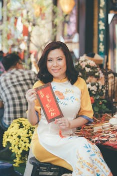 Woman holding a red envelope during a vibrant Vietnamese New Year celebration.