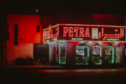 Neon-lit Petra fast-food restaurant exterior in Doha, Qatar during nighttime.