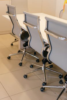 Contemporary office space featuring stylish chairs and a sleek white table, ideal for corporate settings.