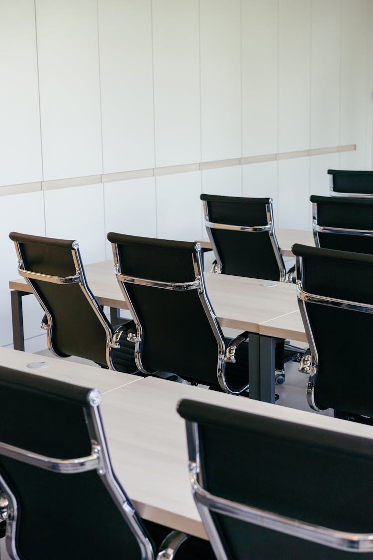 Office Chairs And Wooden Desks Inside An Auditorium