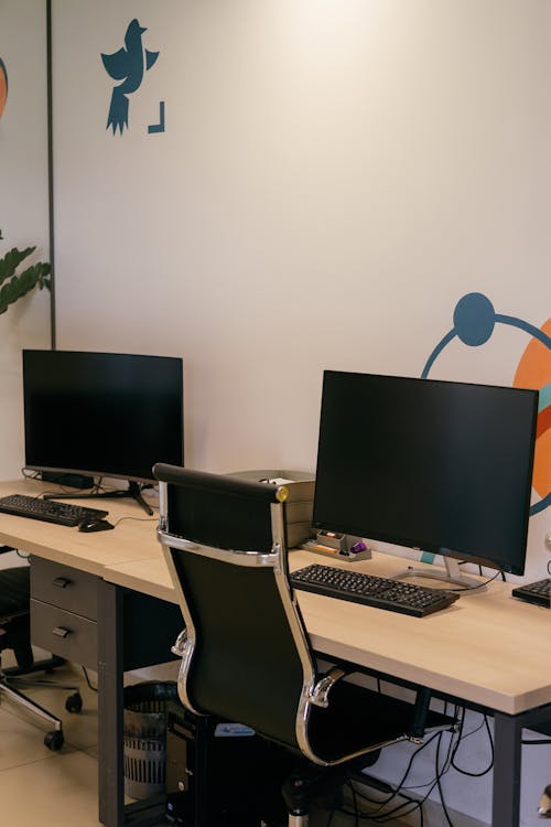 Computers on Wooden Table with Black Office Chair