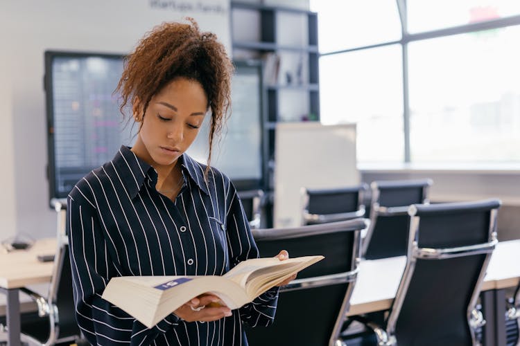 Woman In Striped Long Sleeve Shirt Holding A Book