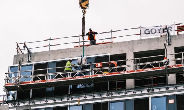 Glass & Window Repair โ Professional workers at a construction site managing equipment on a high-rise building.