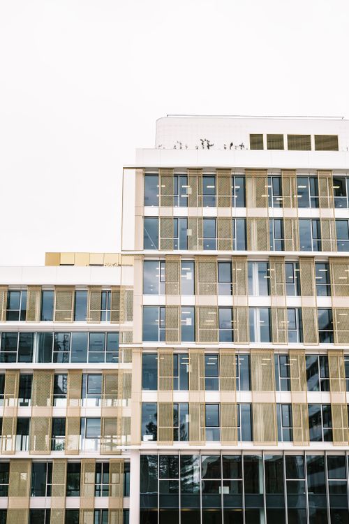 Free Vertical shot of a modern office building with glass and concrete facade. Stock Photo