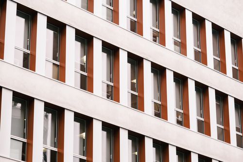 Free Close-up view of a modern building facade showcasing symmetrical windows with contrasting colors. Stock Photo