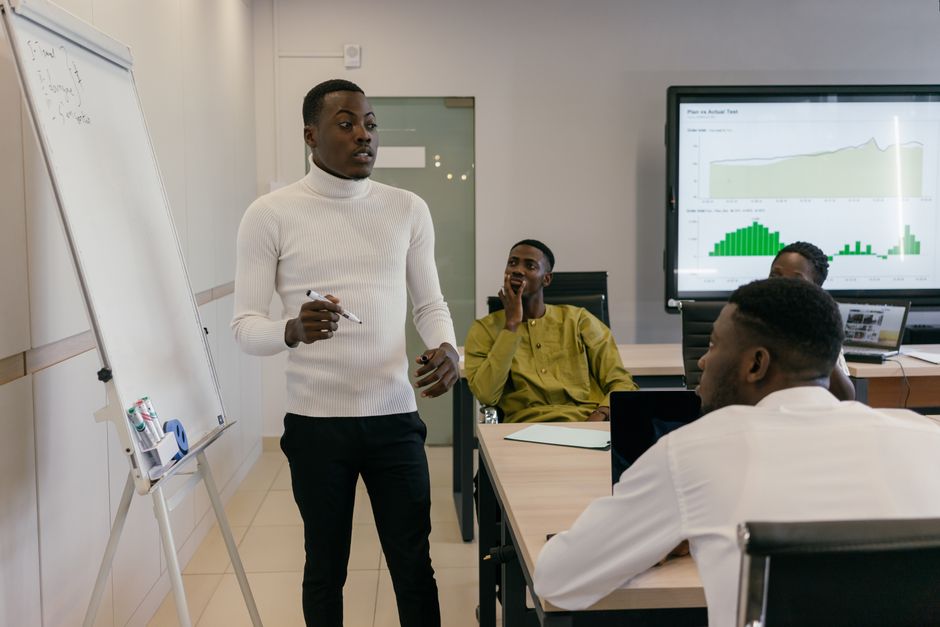 building effective feedback loops for professional growth - Group of professionals discussing business strategy during a presentation in a bright, modern workspace.
