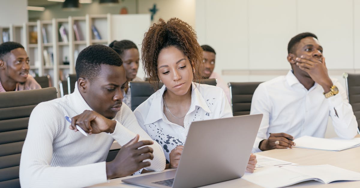 Young African teenagers in sports gear working on a laptop in a bright room
