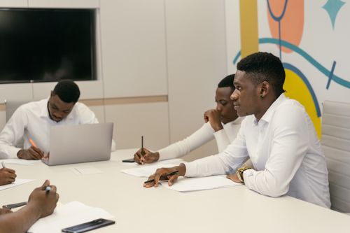 Free Colleagues engage in a professional meeting in a modern conference room, discussing work projects. Stock Photo