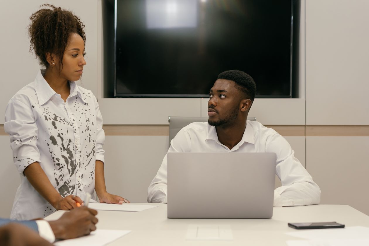 An African cybersecurity professional working on a laptop in an office