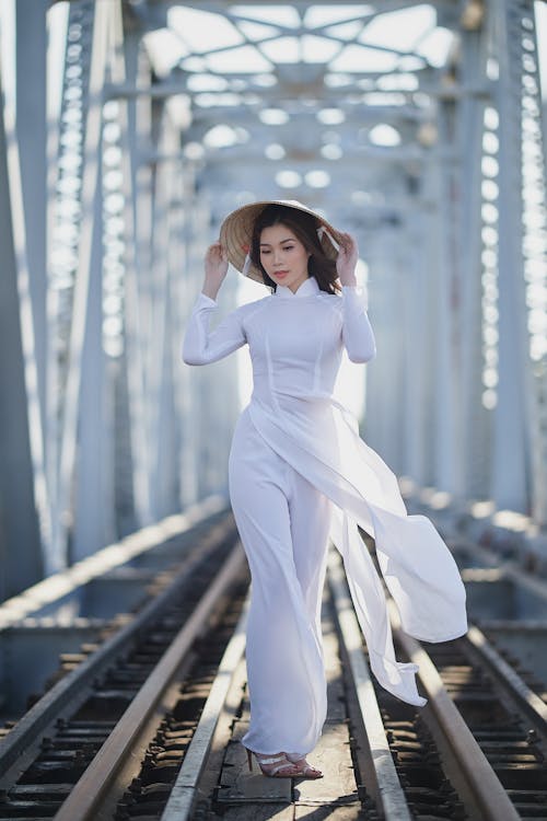 Free Woman in a White Dress Touching Her Hat Stock Photo